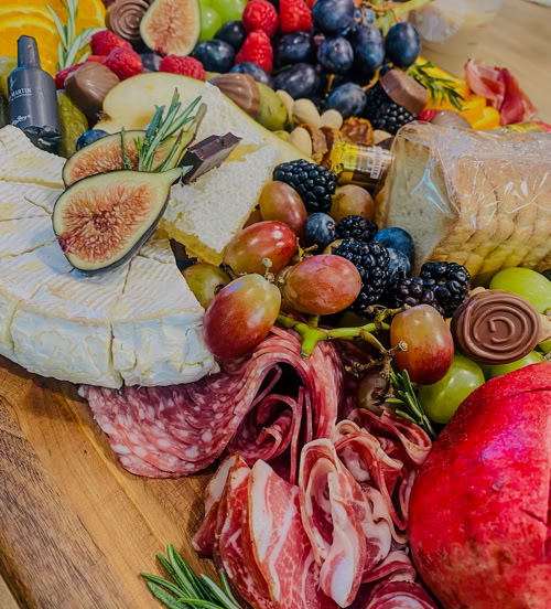 Close-up of artisan charcuterie board with brie, grapes, blackberries, figs, crackers, and sliced meats styled for upscale gatherings in san dimas, ca